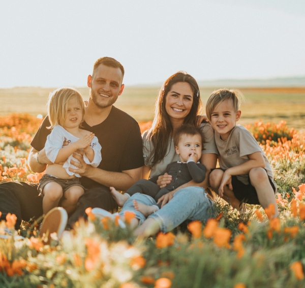 family sitting in a flower field